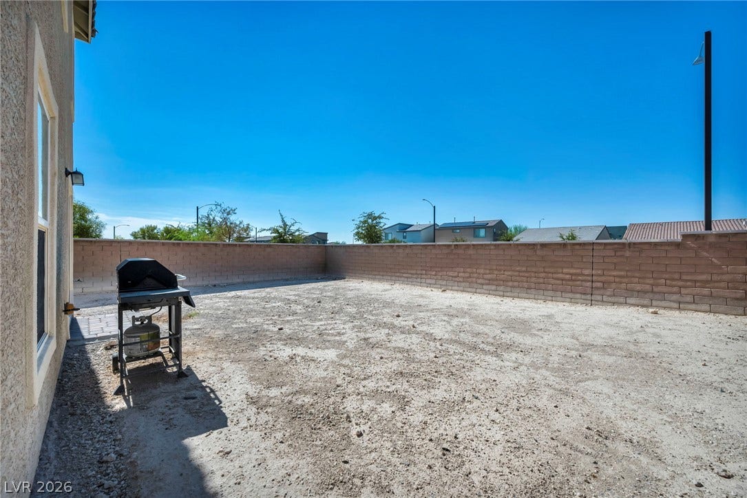 1205 Deep Valley Avenue, North Las Vegas, NV 89084 Block fencing encloses a spacious back lot primed for personalized landscaping design.