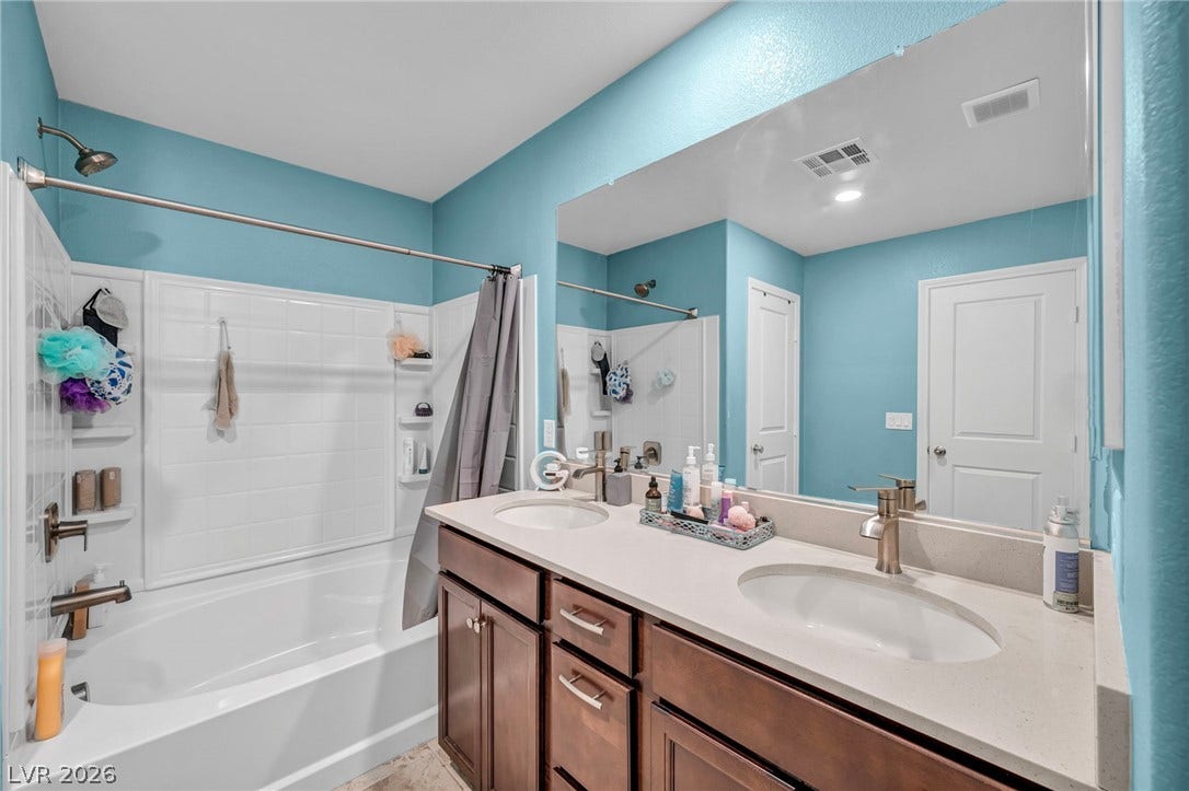 1205 Deep Valley Avenue, North Las Vegas, NV 89084 A spacious double vanity matches the clean tile surrounding the deep soaking tub.