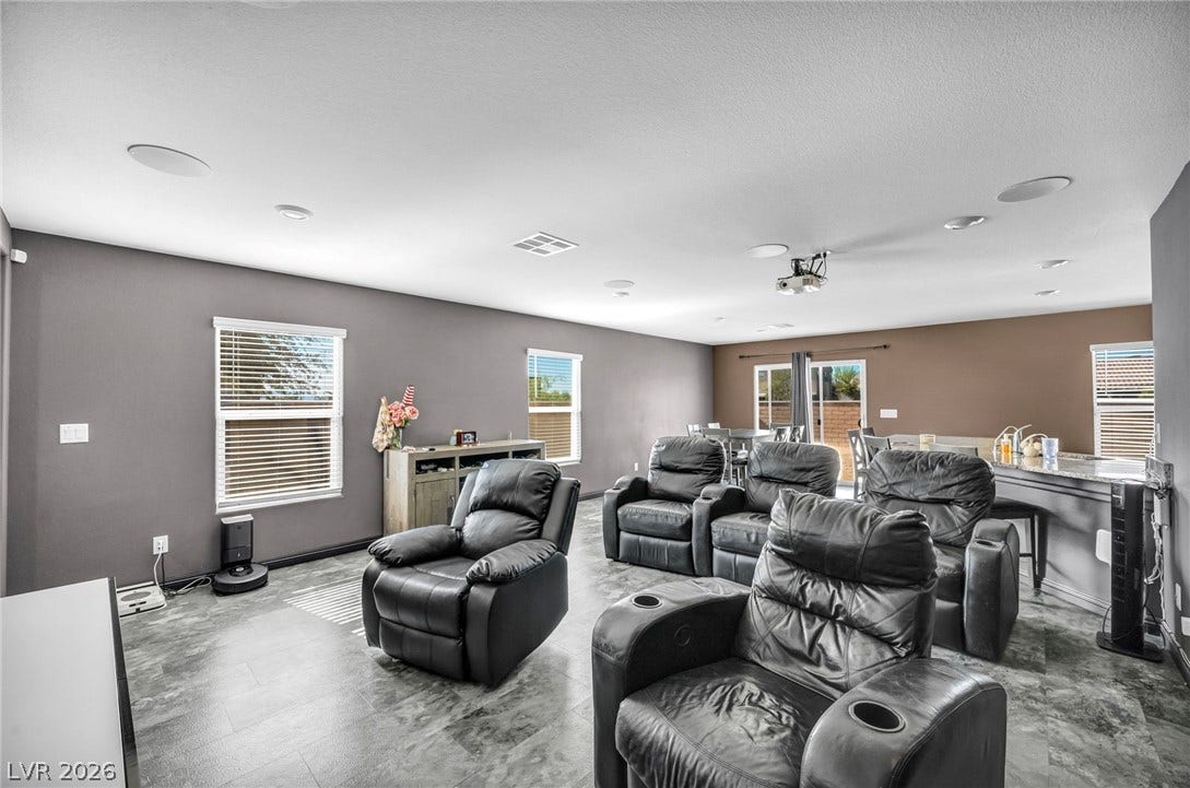 1205 Deep Valley Avenue, North Las Vegas, NV 89084 An open-concept living area incorporates durable tile flooring under a smooth ceiling with integrated speakers.