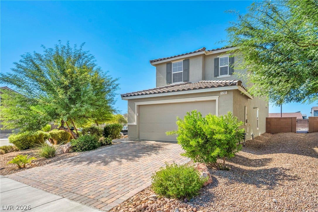 1205 Deep Valley Avenue, North Las Vegas, NV 89084 An inviting two-story exterior showcases a paved driveway and low-maintenance desert landscaping.