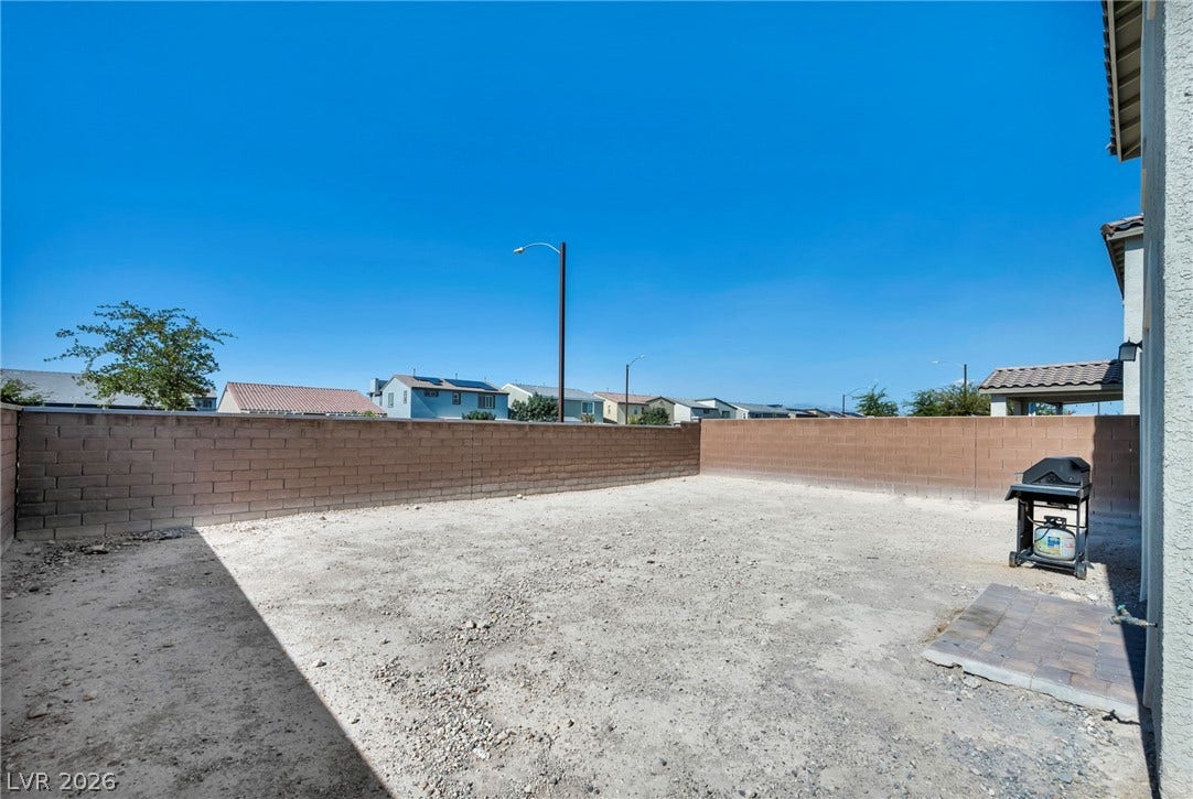 1205 Deep Valley Avenue, North Las Vegas, NV 89084 A spacious block-walled backyard presents a blank canvas ready for custom landscaping.