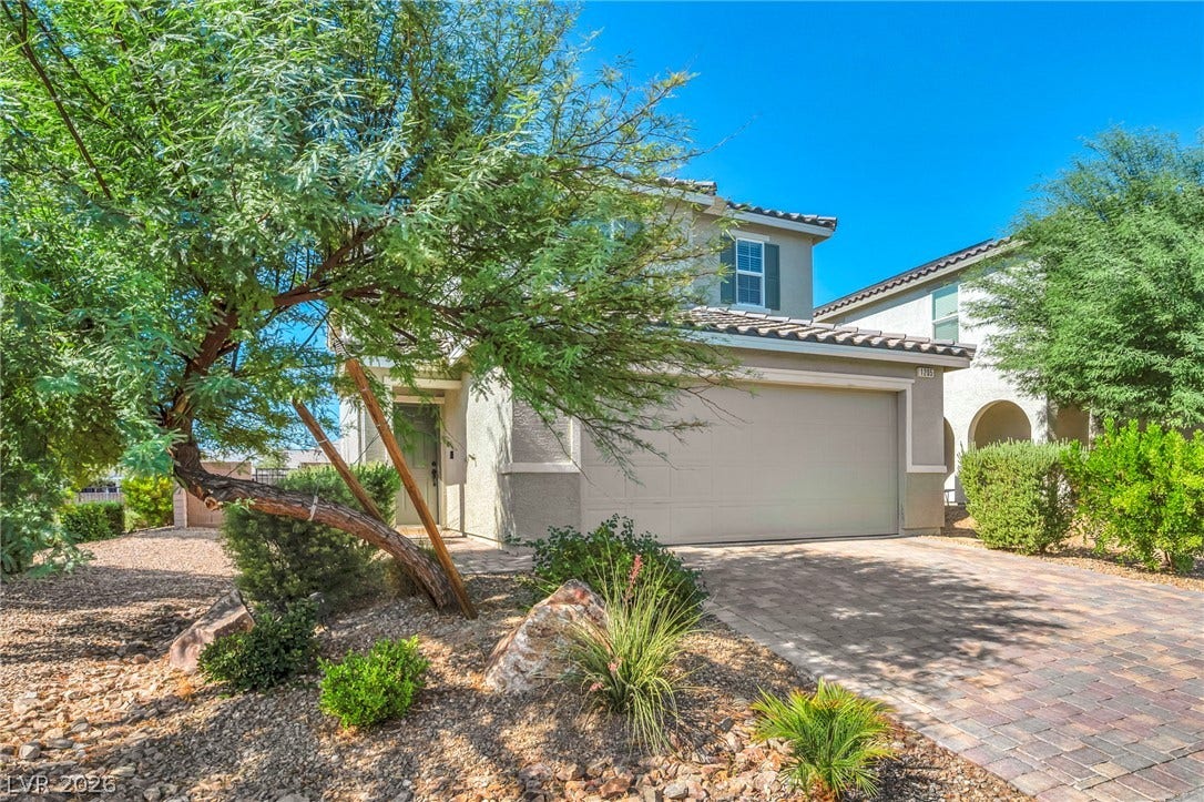 1205 Deep Valley Avenue, North Las Vegas, NV 89084 A paved driveway leads to the integrated garage of this stucco-finished two-level home.