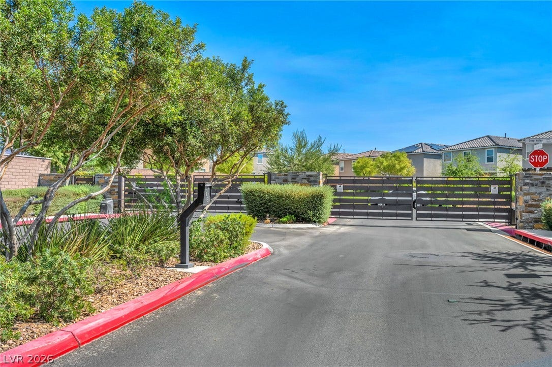 1205 Deep Valley Avenue, North Las Vegas, NV 89084 A secure gated entrance leads into this private residential community under a bright blue sky.