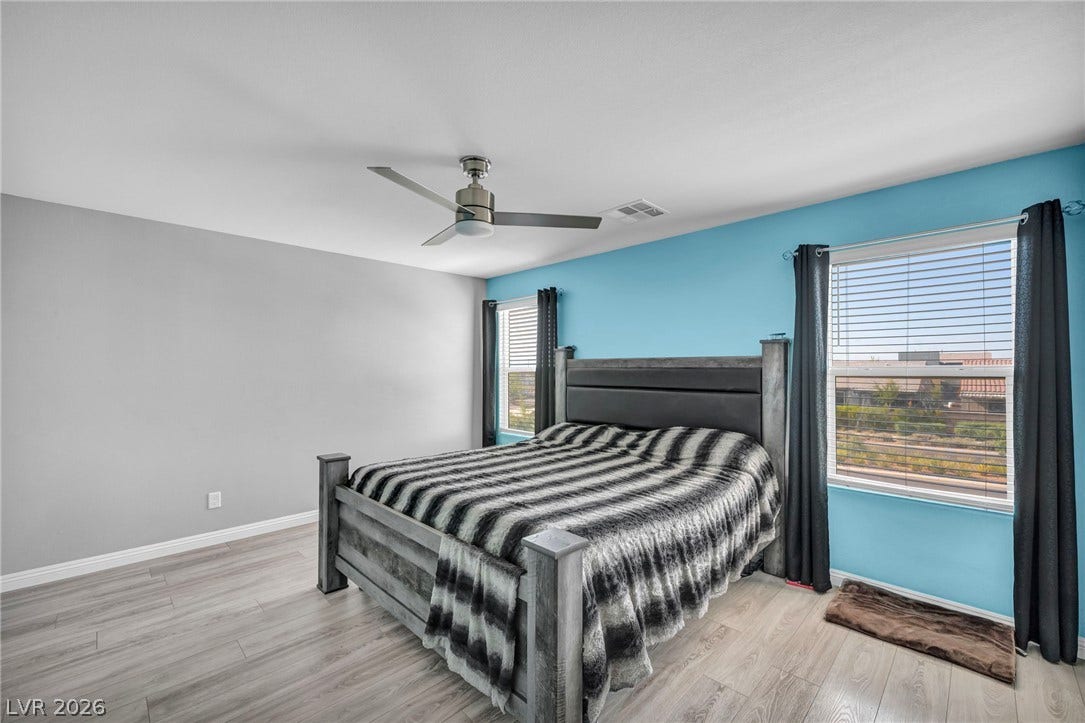 1205 Deep Valley Avenue, North Las Vegas, NV 89084 Double windows frame the view in this bedroom featuring durable wood-look flooring.