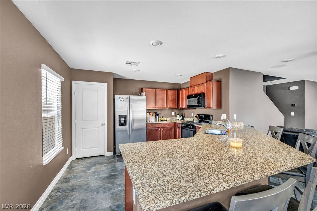 1205 Deep Valley Avenue, North Las Vegas, NV 89084 Rich wood cabinetry contrasts beautifully with granite countertops in this functional open kitchen.