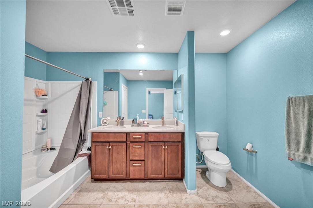 1205 Deep Valley Avenue, North Las Vegas, NV 89084 Tile flooring and a spacious double vanity anchor this modern full bath.