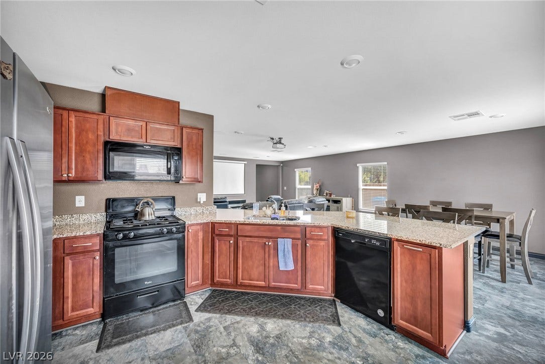 1205 Deep Valley Avenue, North Las Vegas, NV 89084 Granite countertops and warm wood cabinetry anchor this functional open kitchen.