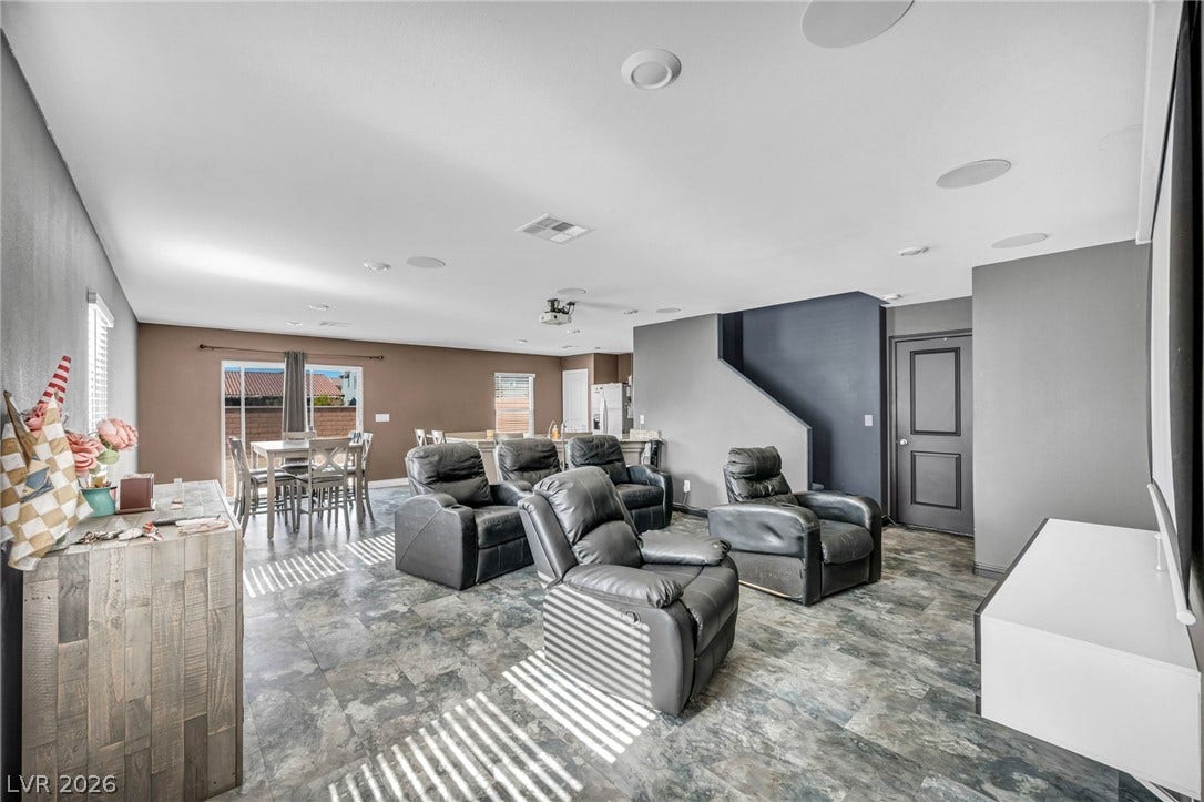 1205 Deep Valley Avenue, North Las Vegas, NV 89084 An open-concept living area integrates tile flooring with recessed lighting and sliding glass doors.