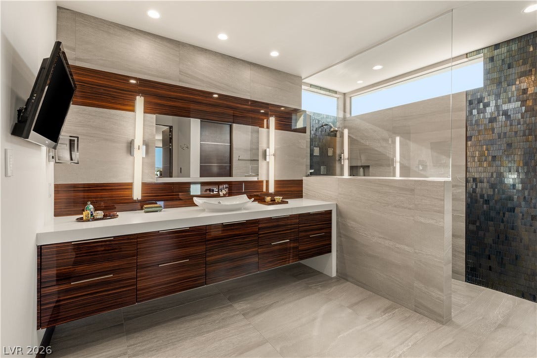 1269 Imperia Drive, Henderson, NV 89052 High-end finishes and a floating wood vanity highlight this contemporary primary bathroom.