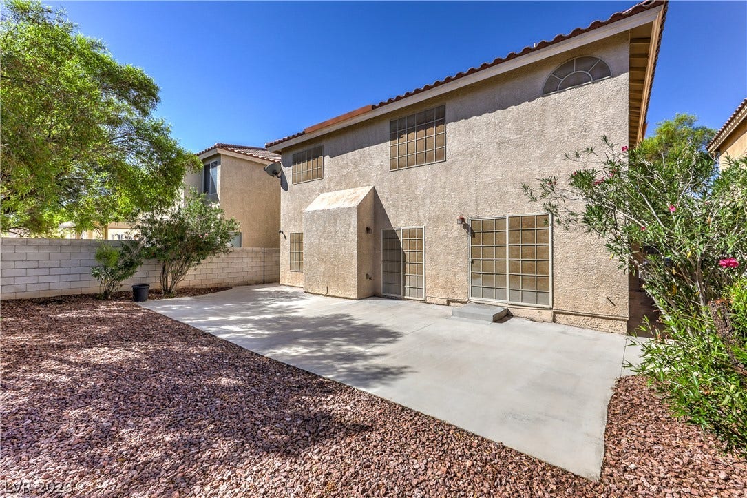 10744 Teton Village Court, Henderson, NV 89052 An expansive concrete patio extends across the backyard of this classic stucco home.