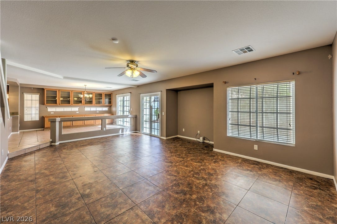 10744 Teton Village Court, Henderson, NV 89052 Tiled flooring flows through a sprawling open layout with built-in cabinetry and sliding doors.