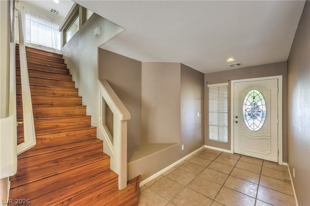 10744 Teton Village Court, Henderson, NV 89052 Rich wood stairs and tiled flooring greet arrivals in this inviting entrance foyer.