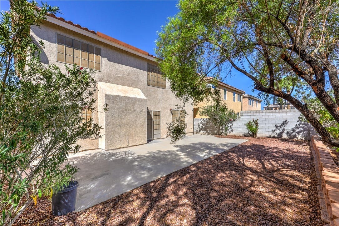 10744 Teton Village Court, Henderson, NV 89052 Mature trees shade a spacious concrete patio perfect for outdoor relaxation and entertaining.