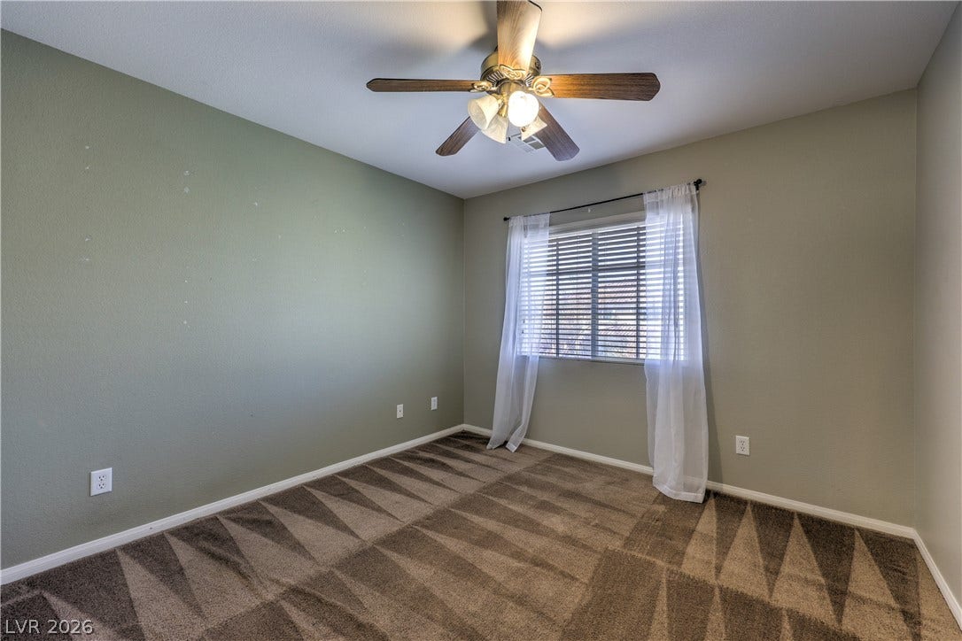 10744 Teton Village Court, Henderson, NV 89052 Plush carpeting and a wide window create a comfortable, inviting atmosphere in this bedroom.