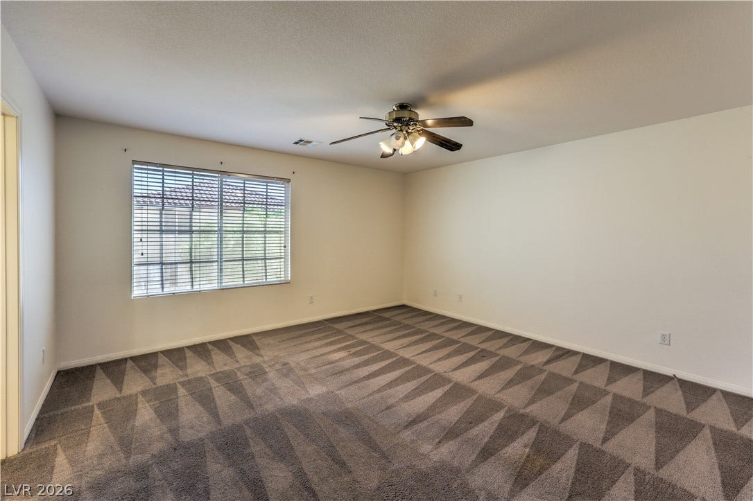 10744 Teton Village Court, Henderson, NV 89052 Plush carpeted flooring and neutral walls anchor this versatile space illuminated by natural light.