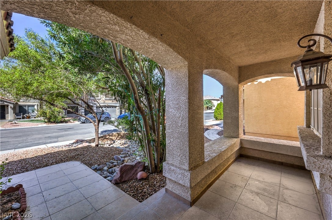 10744 Teton Village Court, Henderson, NV 89052 Tiled flooring and stucco arches frame a welcoming entryway looking out toward the neighborhood.