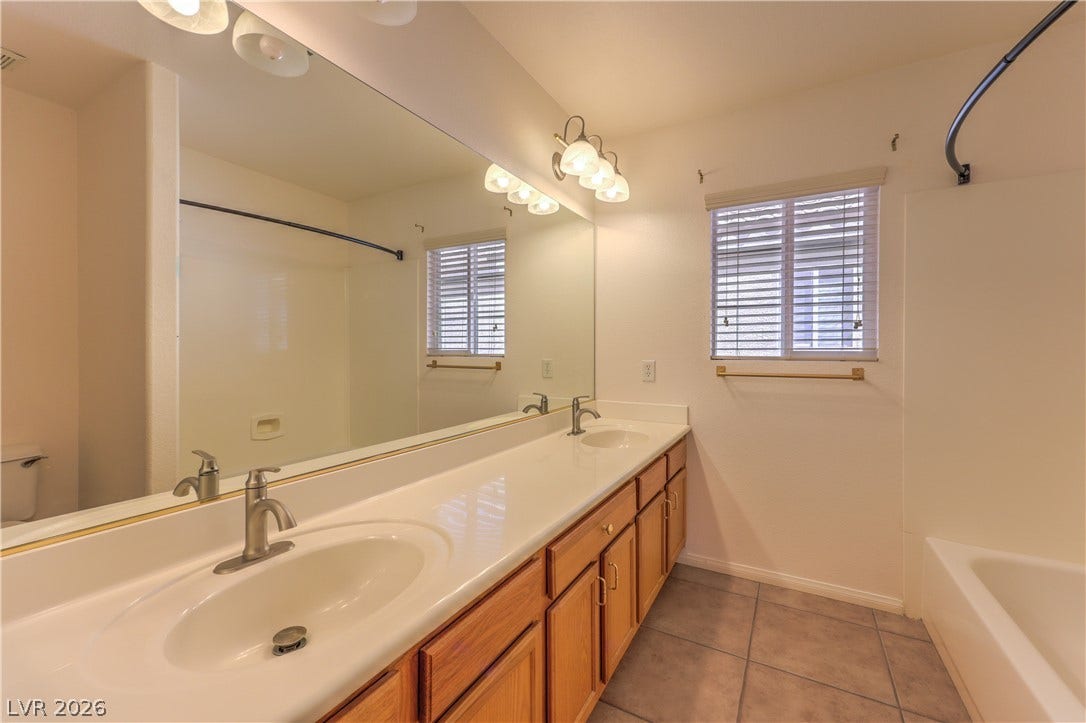 10744 Teton Village Court, Henderson, NV 89052 Tiled flooring pairs with a double vanity in this functional bathroom space.