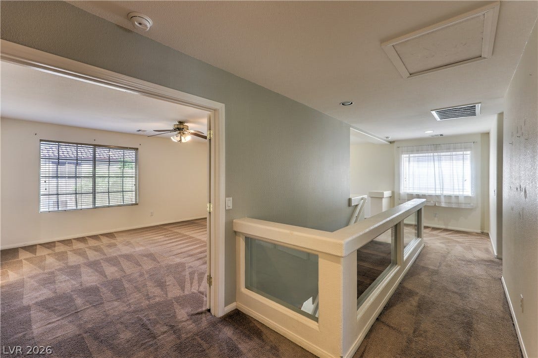 10744 Teton Village Court, Henderson, NV 89052 Plush carpeting and an open stairwell landing connect the upper-level living spaces.