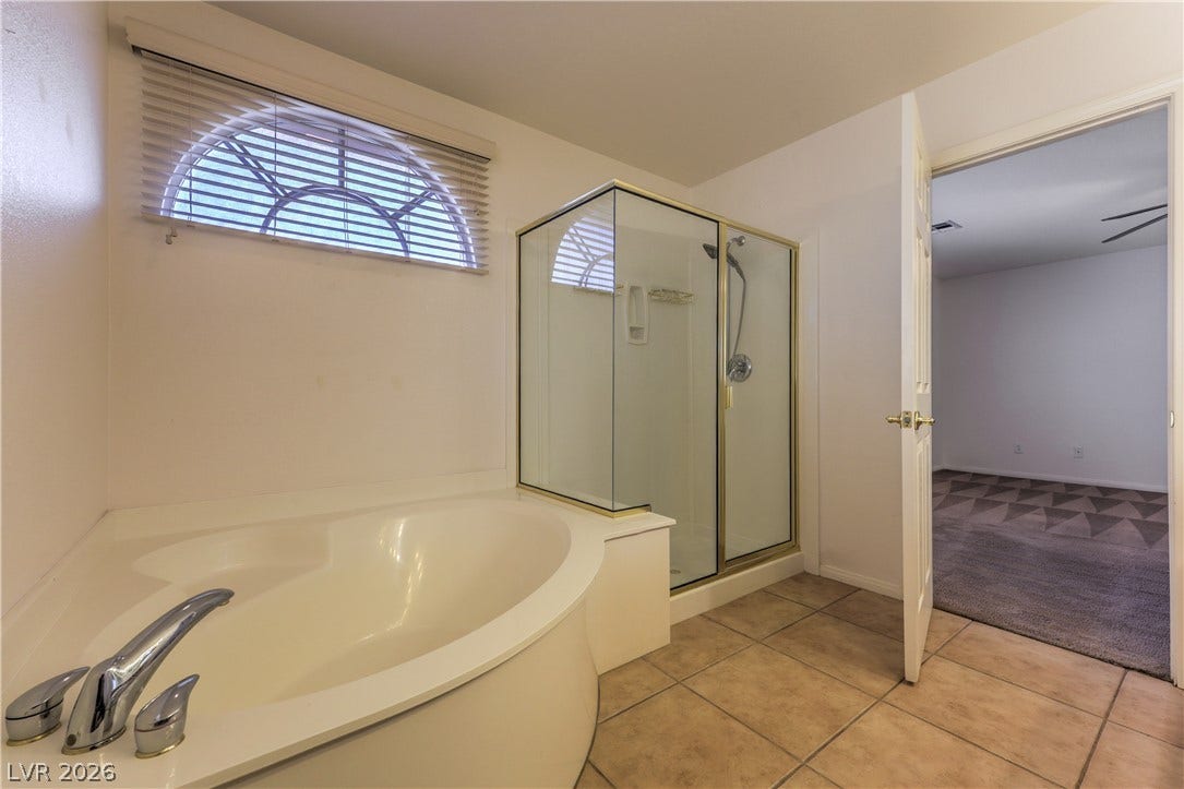 10744 Teton Village Court, Henderson, NV 89052 A spacious soaking tub and a separate glass-enclosed shower highlight this tiled bathroom.