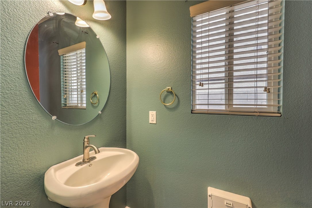 10744 Teton Village Court, Henderson, NV 89052 Textured walls and a classic pedestal sink define this charming powder room space.