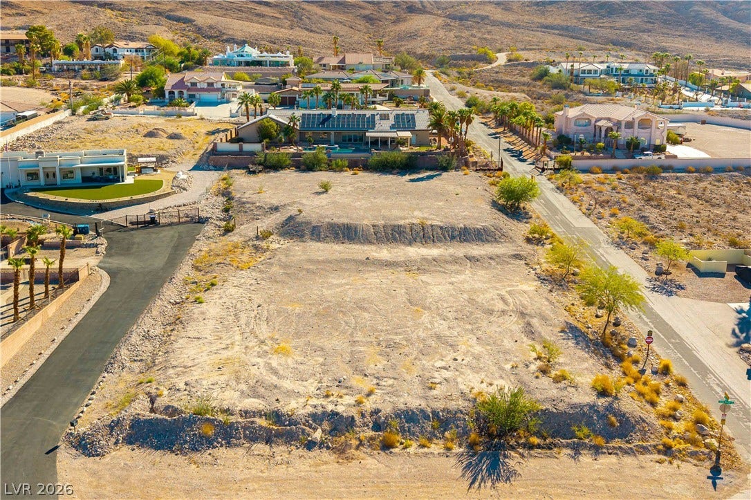 520 Los Feliz Street, Las Vegas, NV 89110 A spacious vacant lot sits nestled in a tranquil desert neighborhood surrounded by rolling hills.