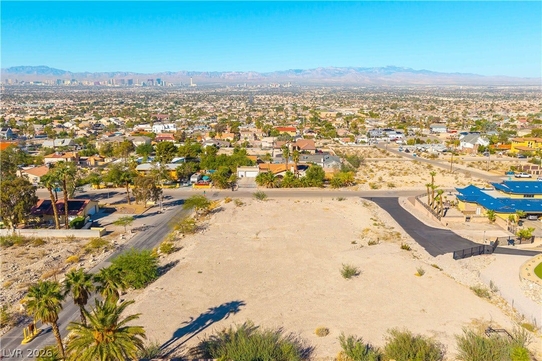 520 Los Feliz Street, Las Vegas, NV 89110 A spacious vacant lot sits prepared for construction against a majestic mountain backdrop.