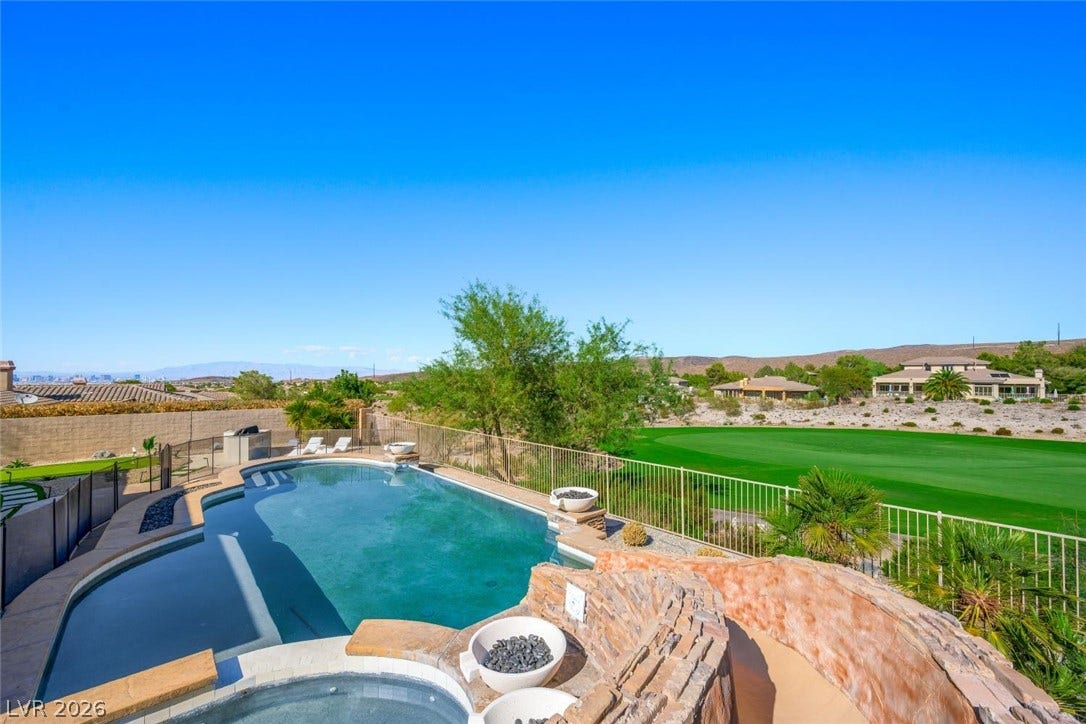 18 Wade Hampton Trail, Henderson, NV 89052 An inviting backyard pool overlooks a lush green golf course and distant desert mountains.