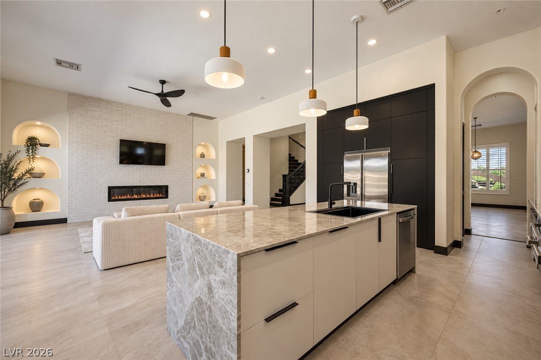18 Wade Hampton Trail, Henderson, NV 89052 Virtually Staged.
An open-concept layout seamlessly connects the kitchen island to the fireplace-accented living room.
