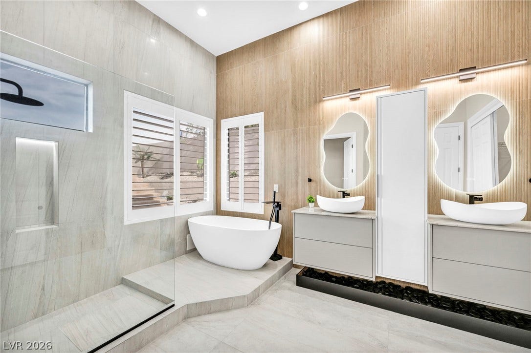 18 Wade Hampton Trail, Henderson, NV 89052 A freestanding tub and sleek glass-enclosed shower anchor this modern sanctuary.