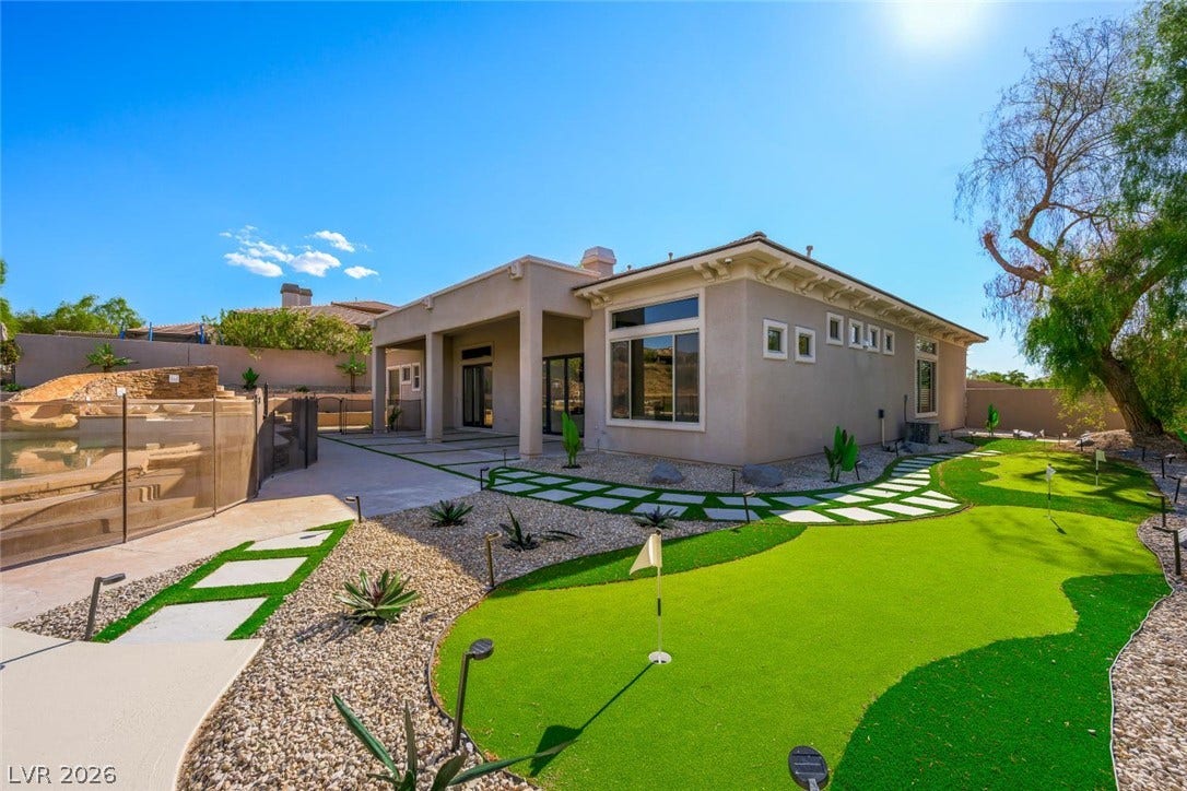 18 Wade Hampton Trail, Henderson, NV 89052 A backyard putting green sits alongside a modern desert home with stone landscaping.