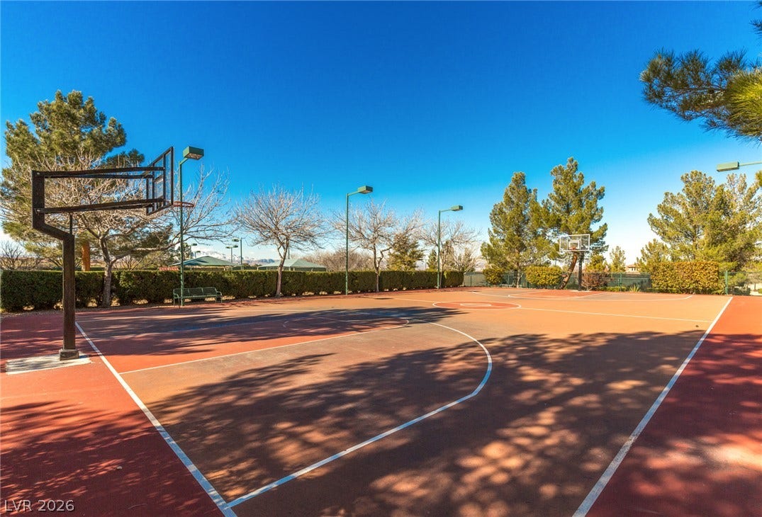 18 Wade Hampton Trail, Henderson, NV 89052 A spacious outdoor basketball court offers high-quality athletic play under clear blue skies.