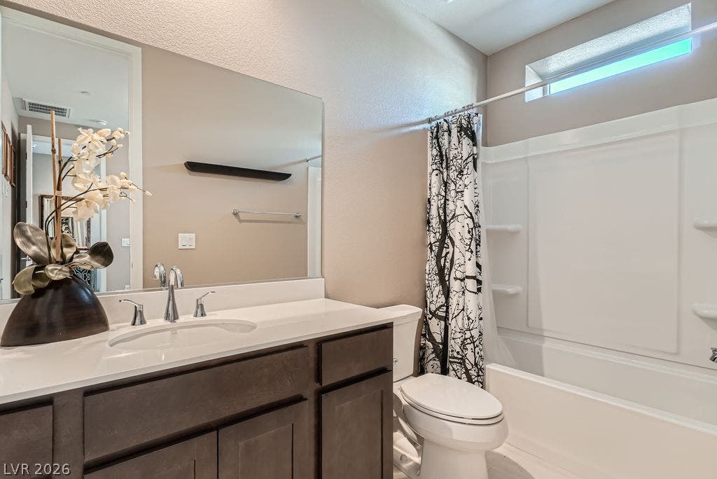 2507 Silent View Avenue, Henderson, NV 89044 Modern cabinetry and solid surface counters elevate this functional bathroom with an integrated tub-shower combination.