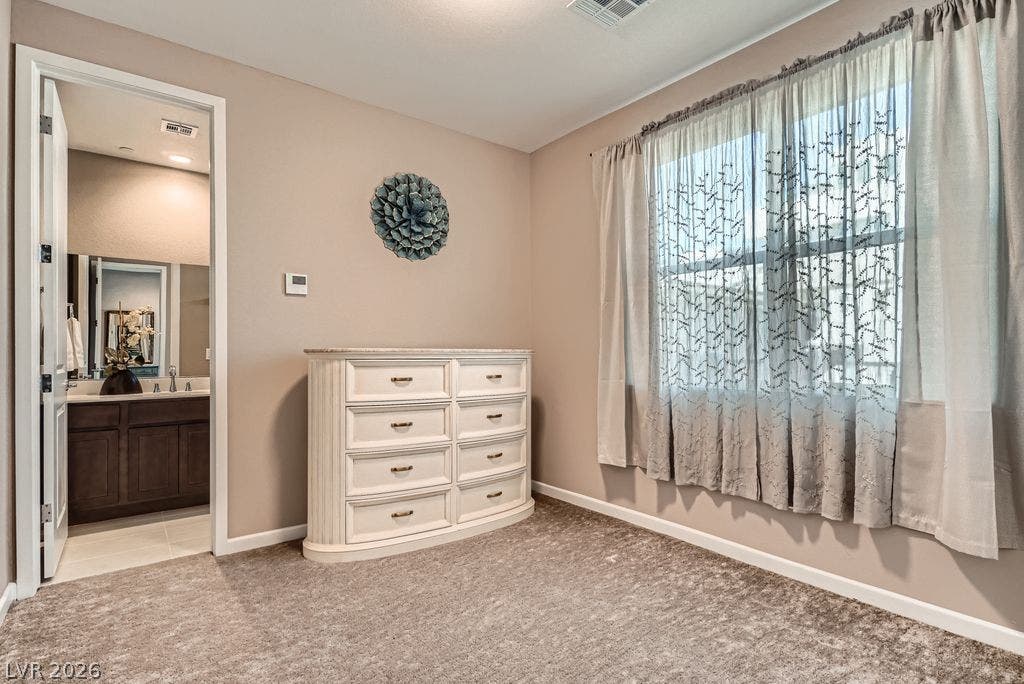 2507 Silent View Avenue, Henderson, NV 89044 Plush carpeting and generous windows define this peaceful bedroom with ensuite bathroom access.