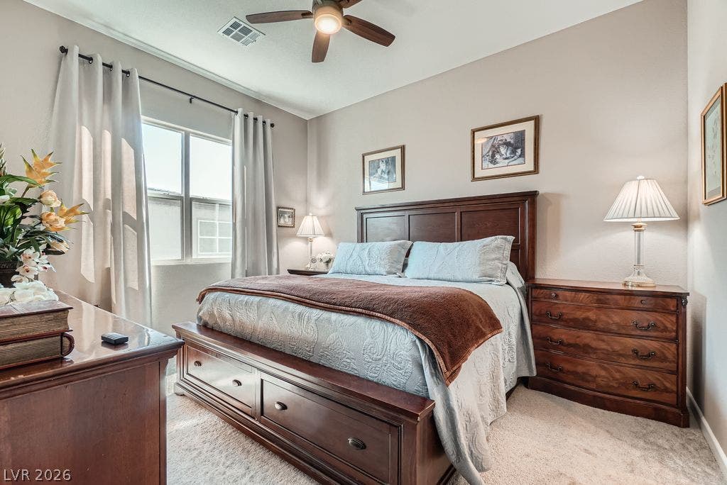 2507 Silent View Avenue, Henderson, NV 89044 Natural light streams through a large window into this peaceful bedroom featuring plush carpeting.
