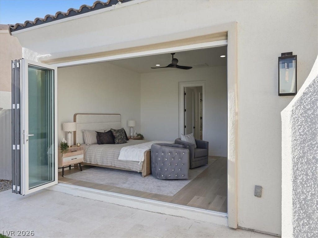 3074 Soft Horizon Way, Las Vegas, NV 89135 Retreat to this serene bedroom, where expansive bi-fold doors open to a private outdoor space, blending indoor comfort with alfresco relaxation.