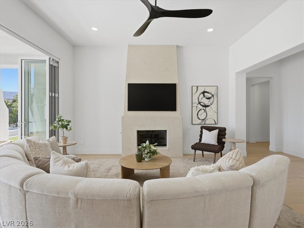 3074 Soft Horizon Way, Las Vegas, NV 89135 A spacious living area features a modern fireplace and sliding glass doors that open to scenic views.