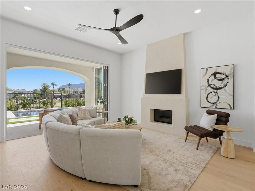 3074 Soft Horizon Way, Las Vegas, NV 89135 An inviting living room features a sleek fireplace and seamless outdoor access to a sparkling pool.