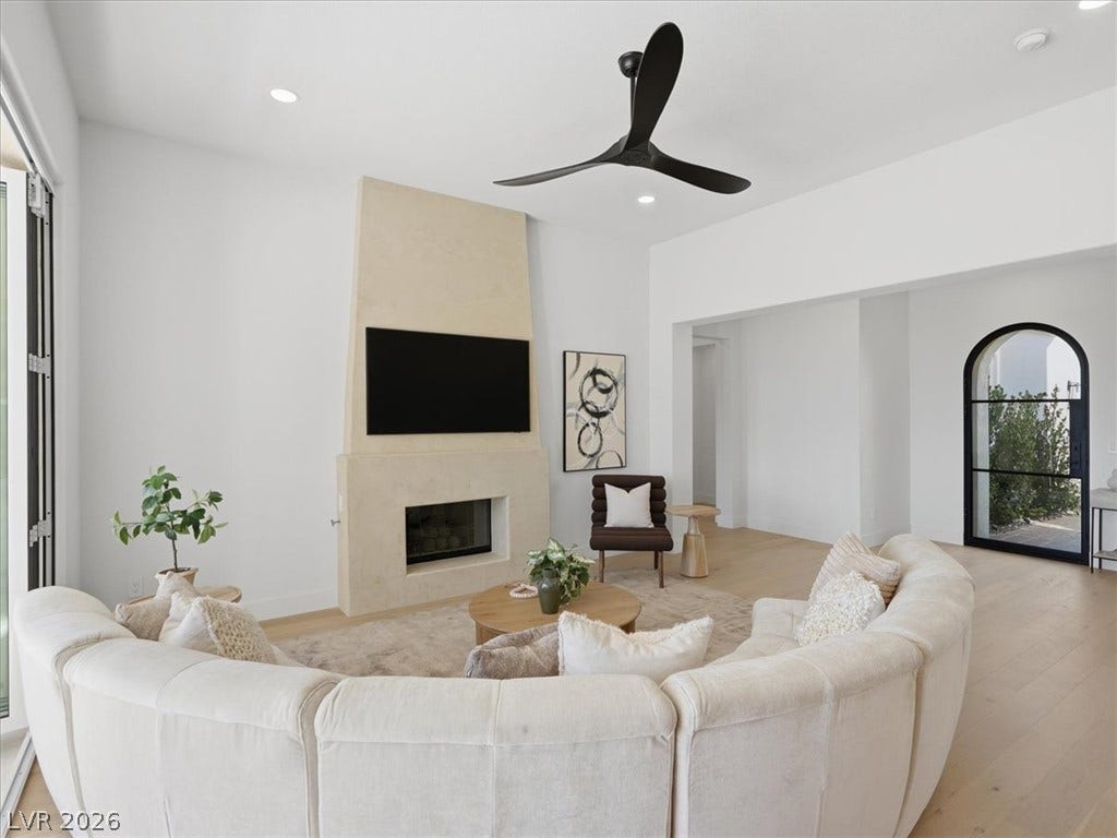 3074 Soft Horizon Way, Las Vegas, NV 89135 A well-lit living area features a modern fireplace and elegant archway door.