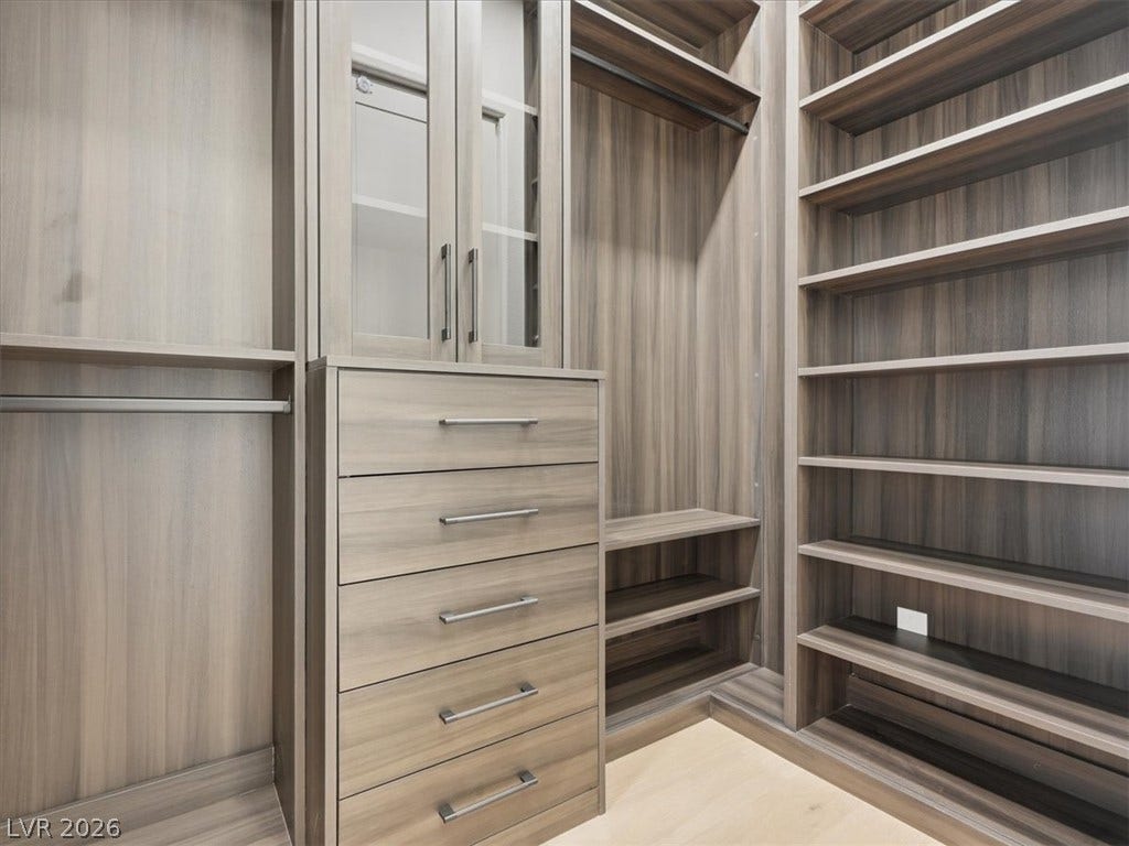 3074 Soft Horizon Way, Las Vegas, NV 89135 Ample storage solutions await in this naturally illuminated walk-in closet with integrated shelving and drawer systems.