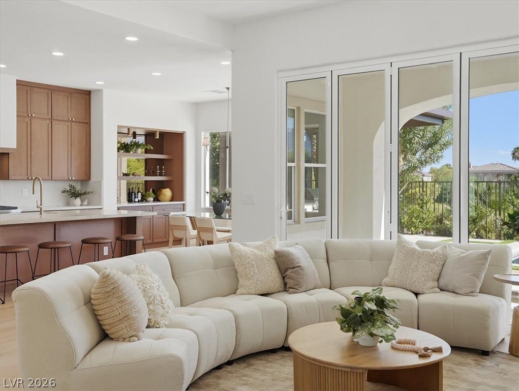 3074 Soft Horizon Way, Las Vegas, NV 89135 An open-concept living space integrates a well-appointed kitchen and a sunny dining area, all overlooking a lush landscape through expansive glass doors.