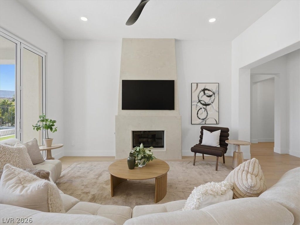 3074 Soft Horizon Way, Las Vegas, NV 89135 A well-lit living area showcases a sleek fireplace and direct access to outdoor views.