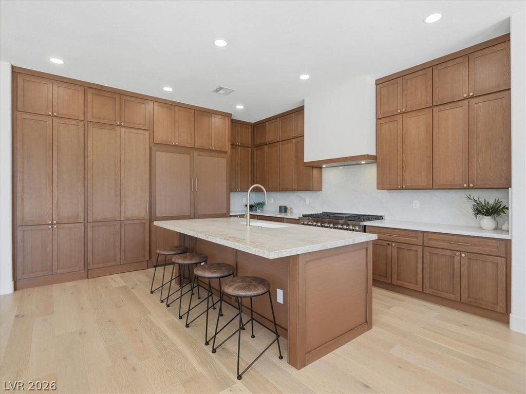 3074 Soft Horizon Way, Las Vegas, NV 89135 Culinary excellence awaits in this kitchen featuring abundant wood cabinetry and a central island with bar seating.