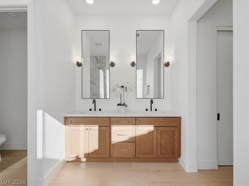 3074 Soft Horizon Way, Las Vegas, NV 89135 A well-lit primary bathroom features a double vanity with ample storage and sleek modern mirrors.