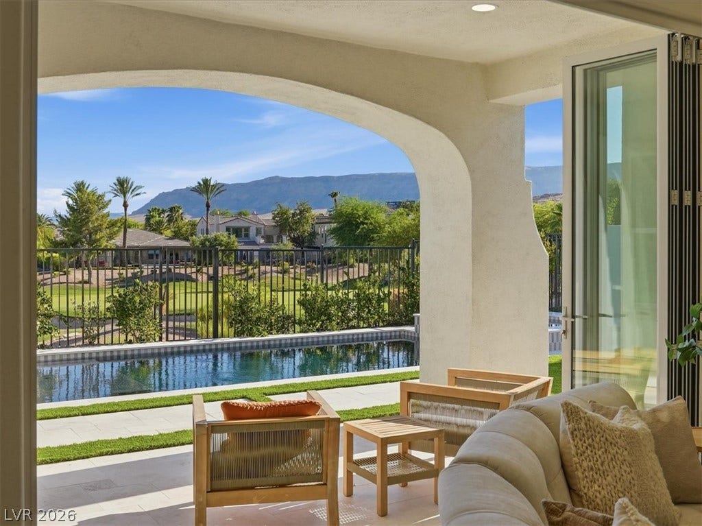 3074 Soft Horizon Way, Las Vegas, NV 89135 An inviting outdoor living area seamlessly connects to a pristine pool, offering mountain views beyond.