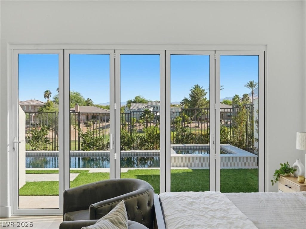 3074 Soft Horizon Way, Las Vegas, NV 89135 Floor-to-ceiling glass doors offer unobstructed views of the inviting pool and verdant landscape.