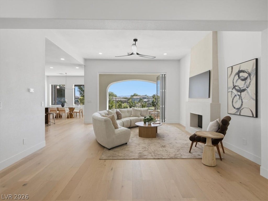 3074 Soft Horizon Way, Las Vegas, NV 89135 An inviting open-concept living area with light wood flooring flows seamlessly to an outdoor balcony.