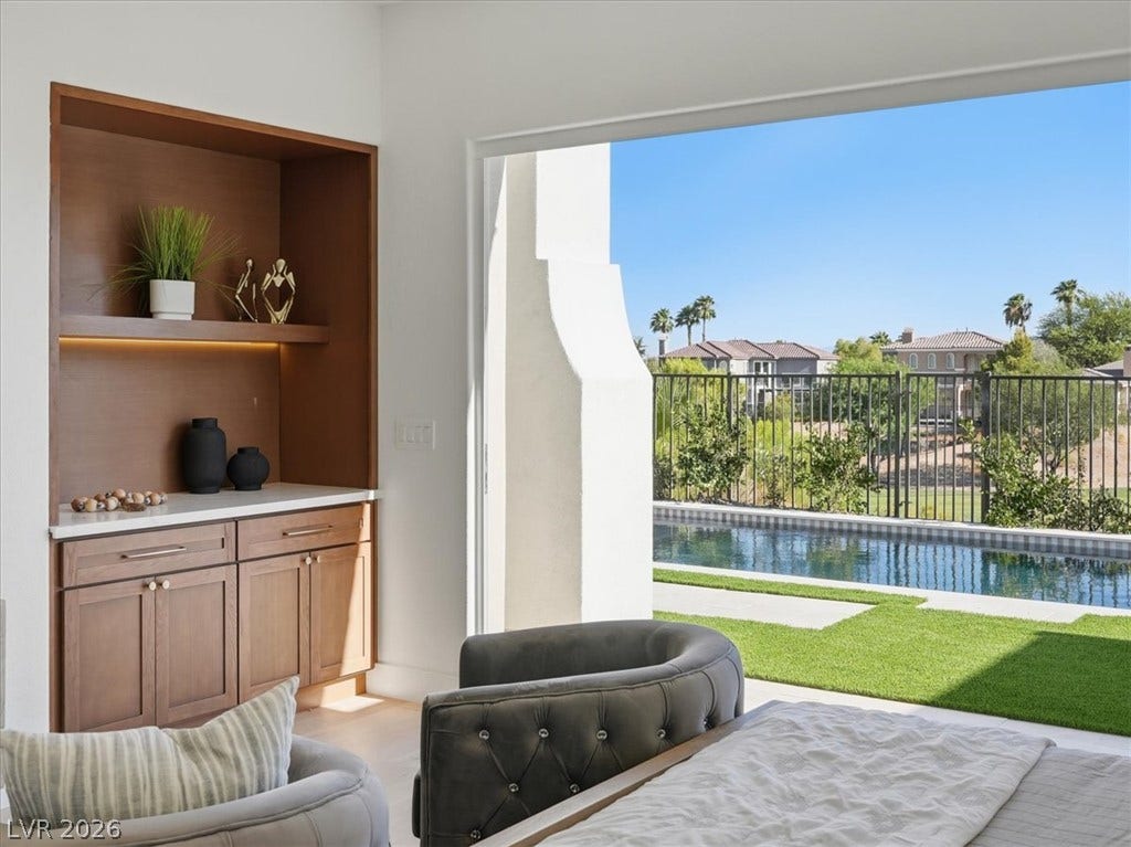 3074 Soft Horizon Way, Las Vegas, NV 89135 A built-in wet bar and floor-to-ceiling glass doors open to a refreshing pool and manicured lawn.