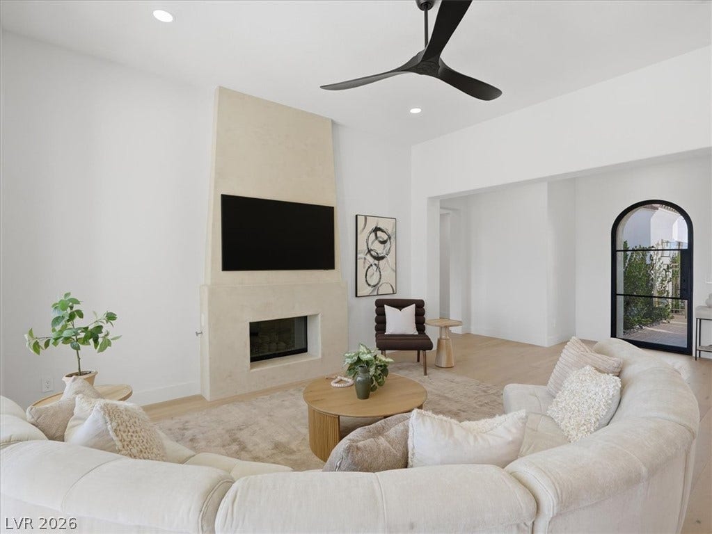 3074 Soft Horizon Way, Las Vegas, NV 89135 A well-lit gathering space features an integrated fireplace and a wide arched entryway.