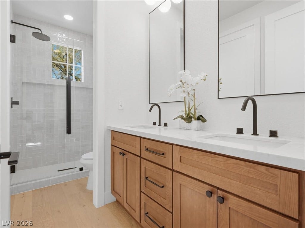 3074 Soft Horizon Way, Las Vegas, NV 89135 A well-appointed primary bathroom showcases a dual vanity with ample storage and a sleek, glass-enclosed shower.