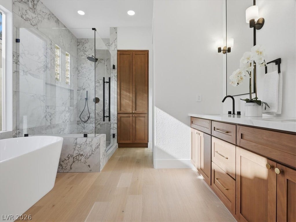 3074 Soft Horizon Way, Las Vegas, NV 89135 Luxurious bathing experience in a well-lit bathroom featuring a deep soaking tub and a spacious walk-in shower.